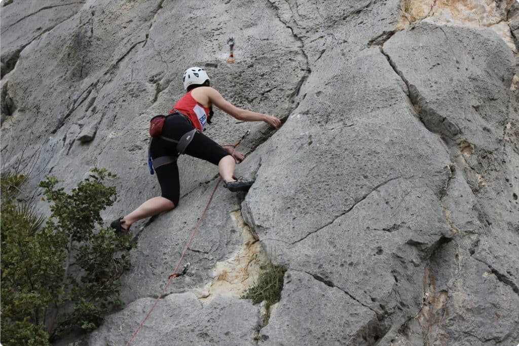 Woman rock climbing on rugged cliff face outdoors
