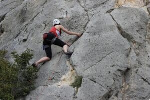 Woman rock climbing on rugged cliff face outdoors